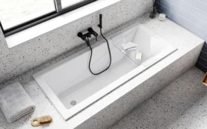 Prostokątna wanna akrylowa Besco Modern Slim w blacie z lastryko terrazzo z czarną armaturą podtynkową
