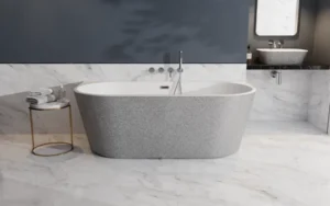 Srebrna wanna wolnostojąca przyścienna Besco Vica New Glam w łazience w białym marmurze ze złotym stolikiem.