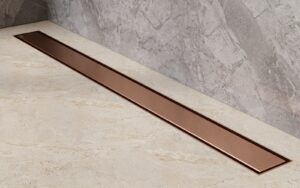 Luksusowy odpływ liniowy miedź szczotkowana Besco Virgo Copper Duo wklejony w jasne beżowe płytki podłogowe
