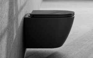 Detal i zbliżenie na matowe wykończenie czarnej podwieszanej miski WC Besco Aspen zamontowanej na betonowej ścianie.