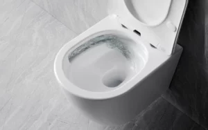 Nowoczesna miska WC Besco – design, higiena i technologia wirowa Podwieszana miska WC Besco w kolorze białym z otwartą, wolnoopadającą deską podczas spłukiwania wody.